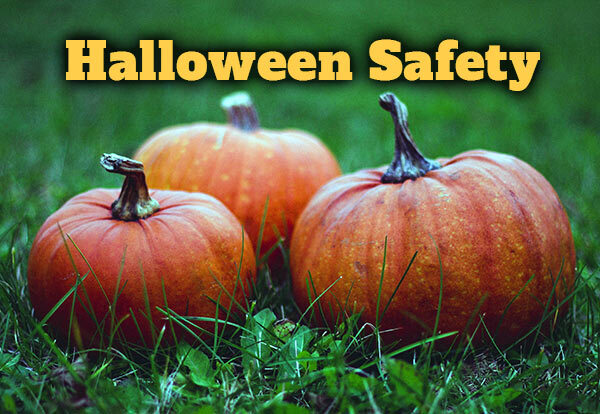 Three pumpkins sitting on the ground with the text Halloween Safety.